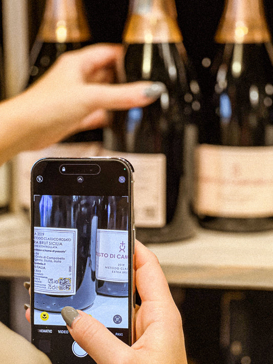 Photo of a wine professional scanning a wine label on their phone to access nutritional information about wine